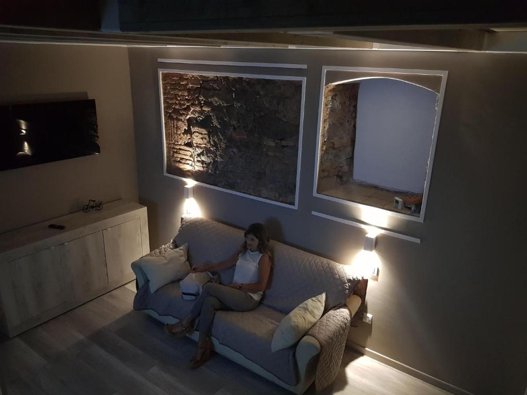 una donna seduta su un divano in soggiorno di LISA HOUSE a Catania