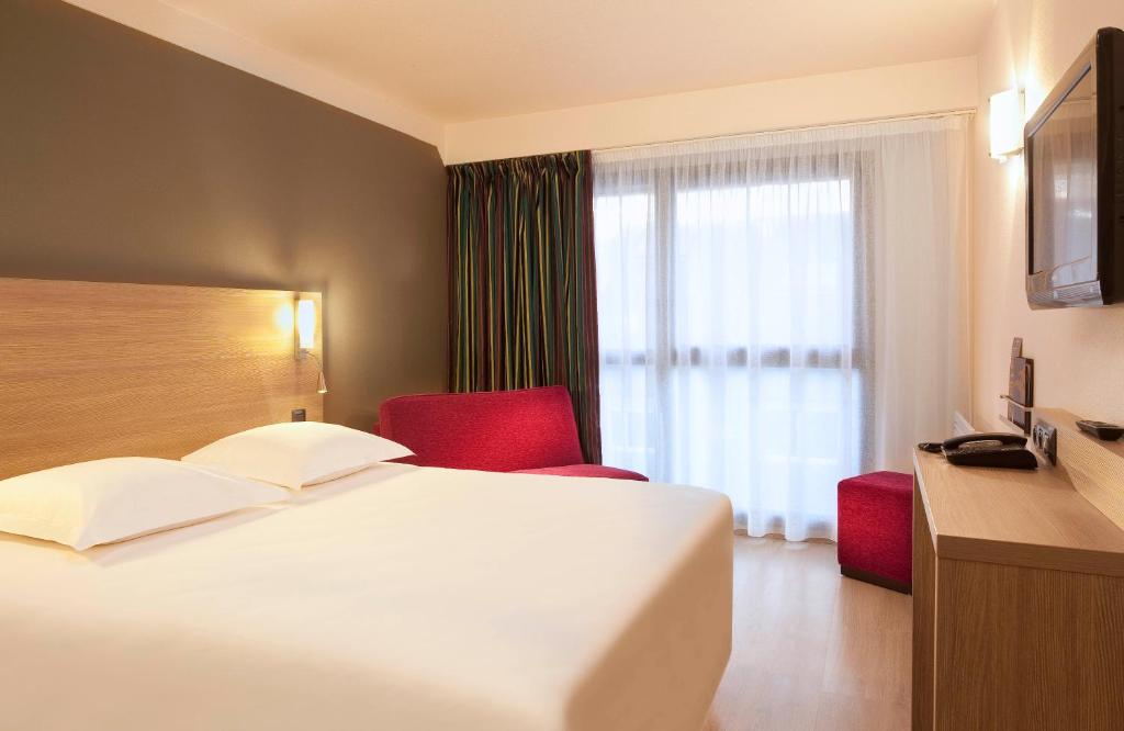a hotel room with a bed and a window at Escale Oceania Quimper Centre in Quimper