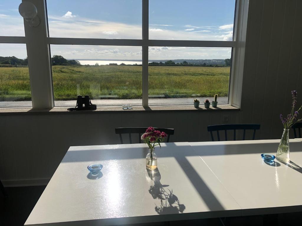 a table with flowers in a room with a window at Samsted in Middelfart