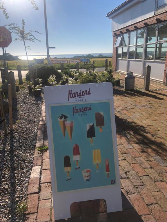 a sign in front of a building with ice cream at Samsted in Middelfart
