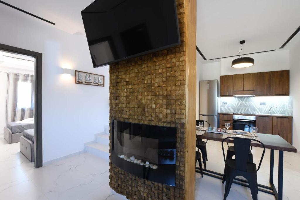 a kitchen and living room with a brick fireplace at Orion Eco Suites in Karteros