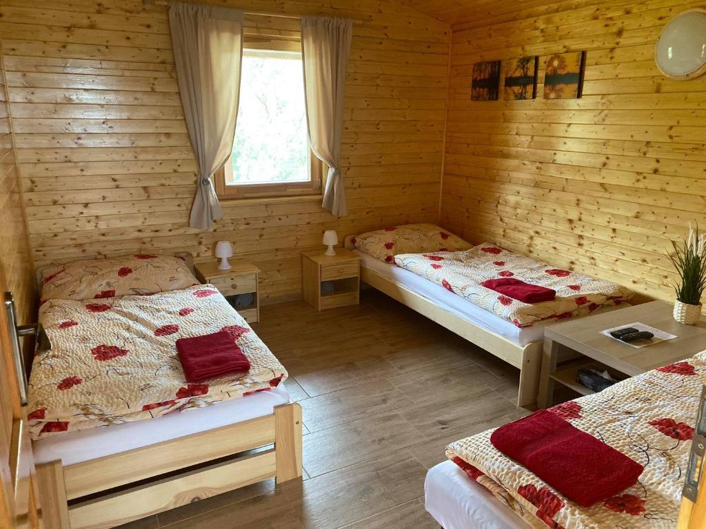 a room with two beds in a log cabin at Chata pri jazere - 6km od Slovakia Ringu in Horná Potôň