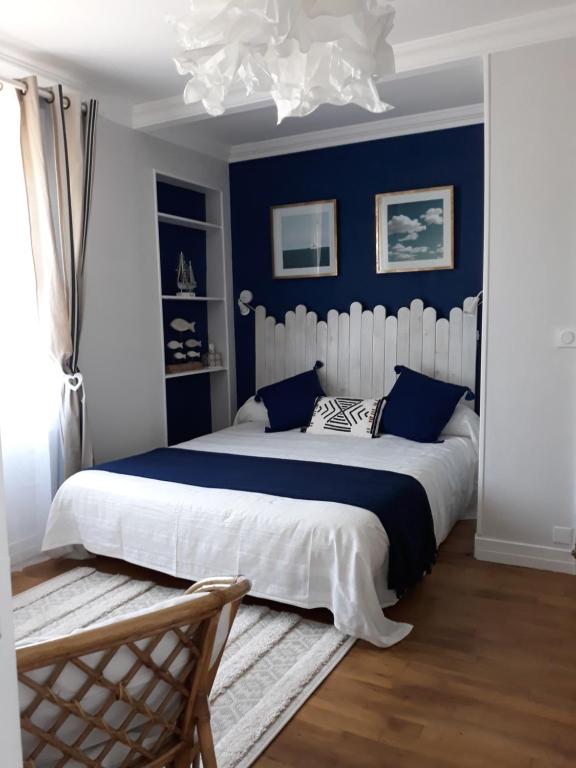 een slaapkamer met een groot bed met blauwe muren bij Cale In in Port-Louis