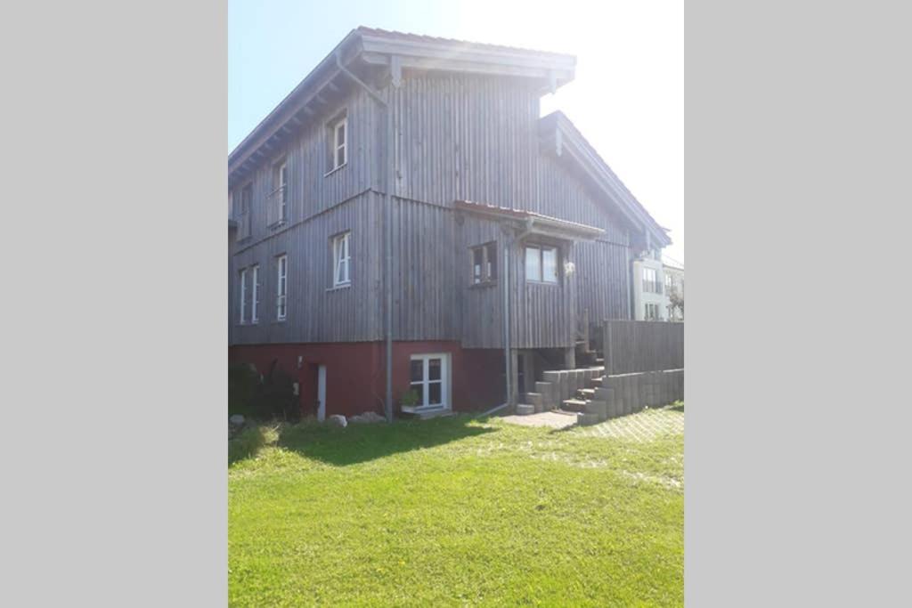 a large wooden house with a green yard in front of it at 2 Ferienhaus Andermichlhof in Geltendorf