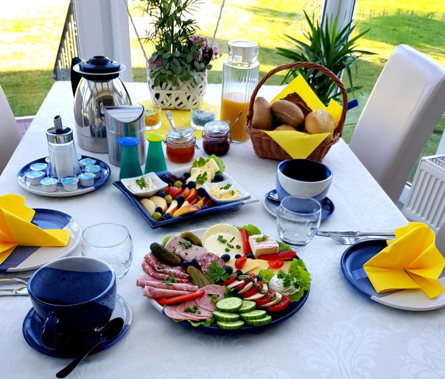 a white table with plates of food on it at Villa Wiese in Katzow