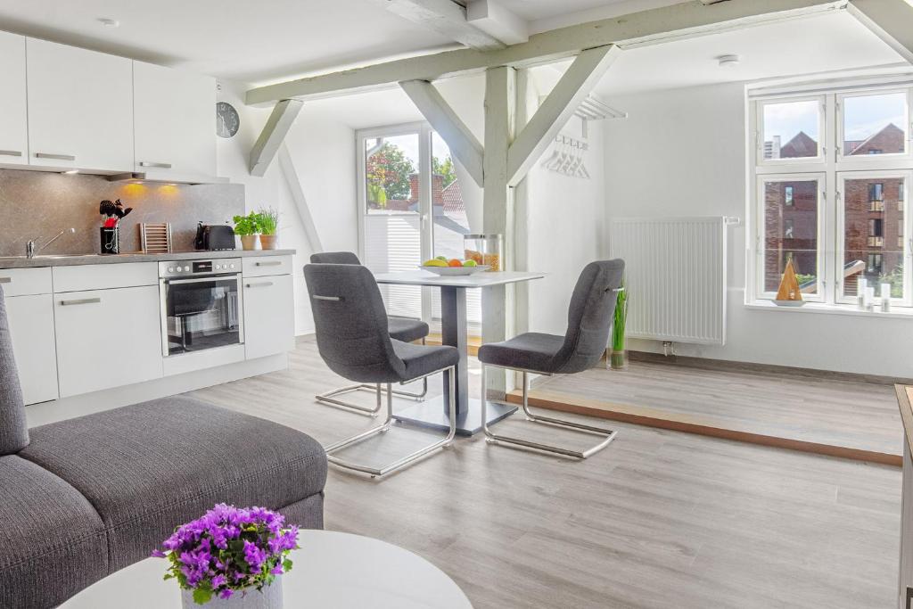 cocina y sala de estar con mesa y sillas en Gutshaus No4, en Heiligenhafen