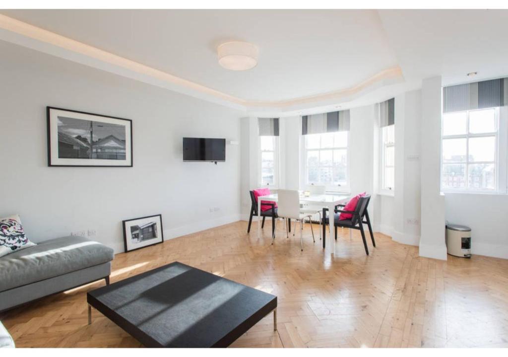 - un salon avec une table et des chaises rouges dans l'établissement JOIVY Bright 1 bed flat, next to Hyde Park, à Londres