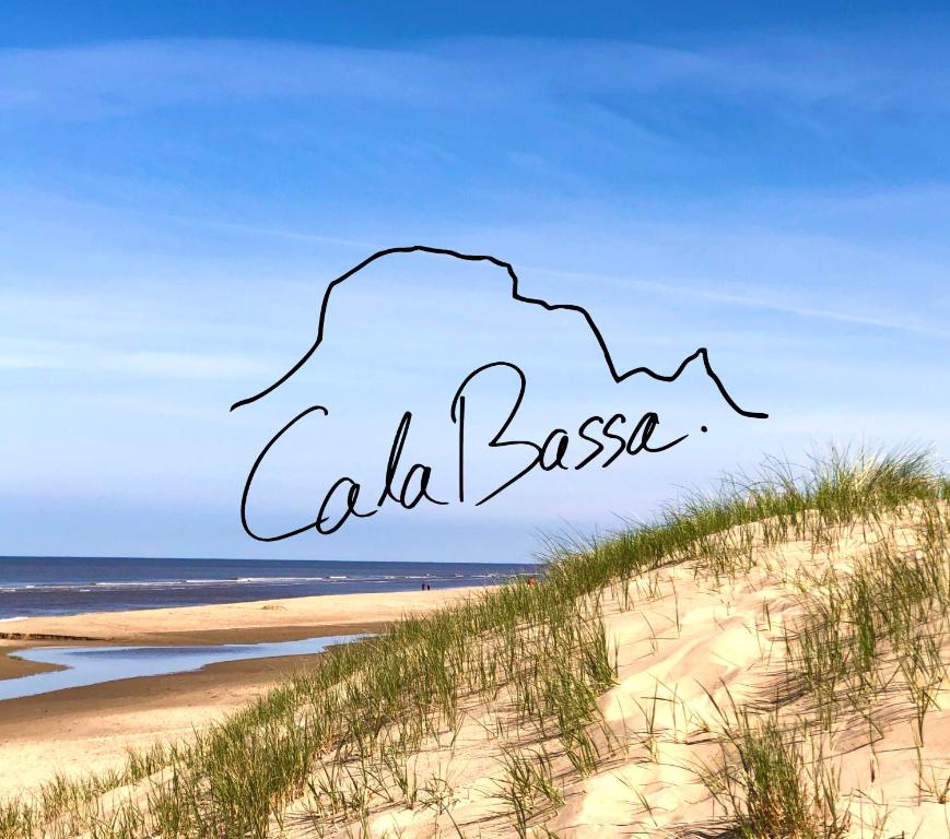 een foto van een strand en de woorden Calella bij Cala Bassa Beachhouse in Noordwijk aan Zee