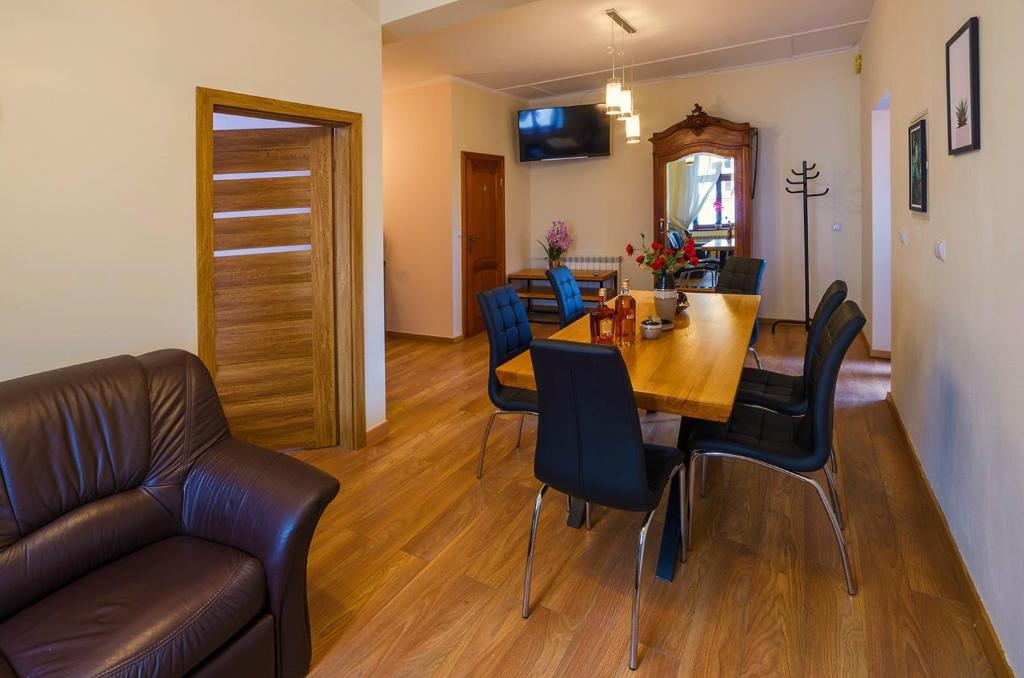 - une salle à manger avec une table, des chaises et un canapé dans l'établissement Perła Wadowic Trybunalska, à Wadowice