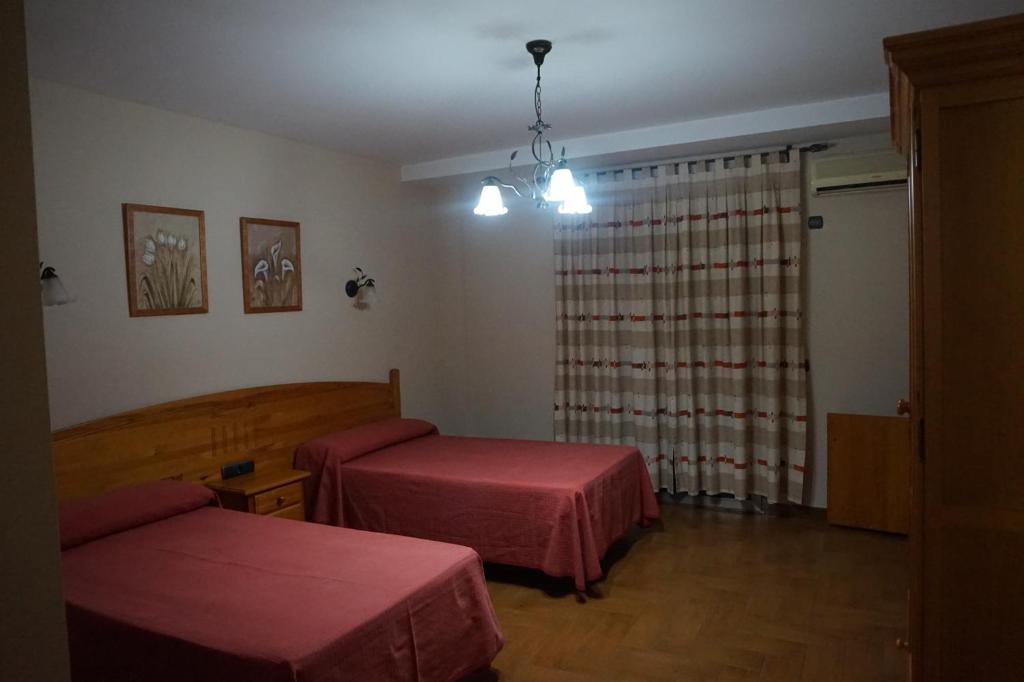 a hospital room with two beds and a window at Hostal Ana in Alhama de Granada