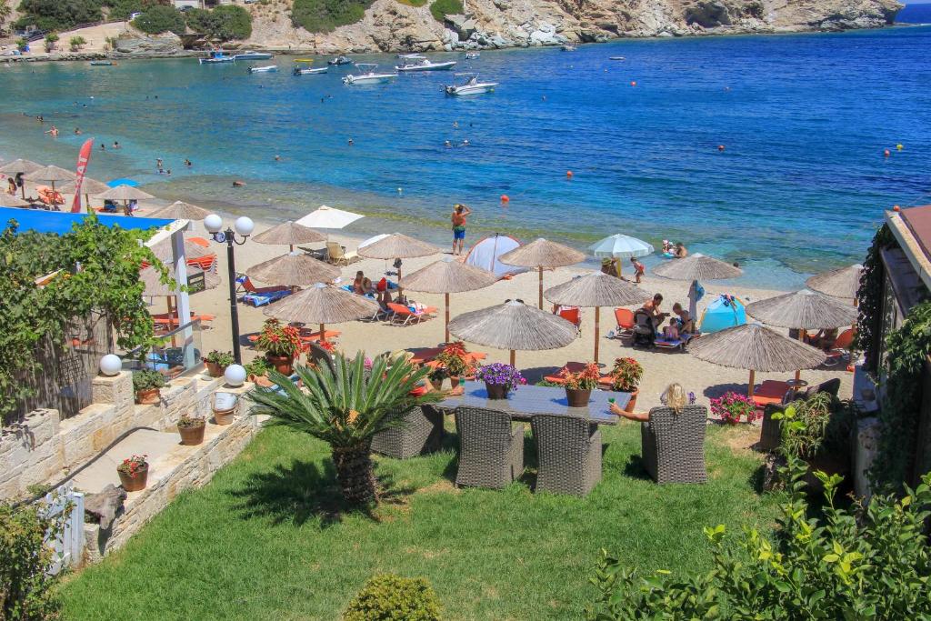 a beach with umbrellas and people on the beach at Apartment Villa Omega in Agia Pelagia
