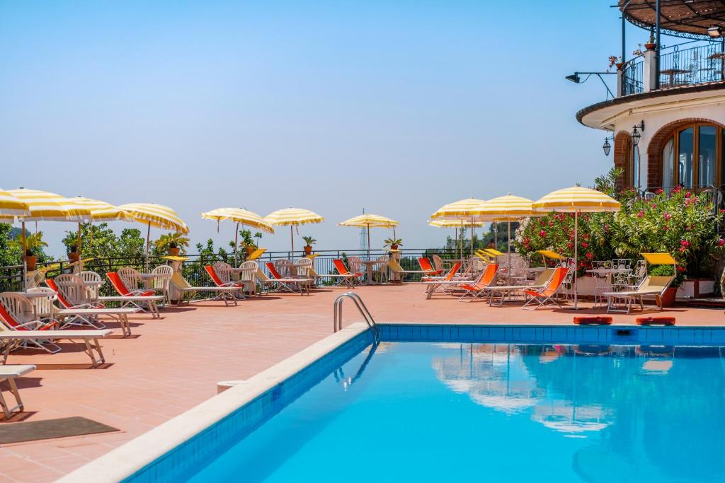 - une piscine avec des chaises longues et des parasols dans l'établissement Hotel Villa Giuseppina, à Scala