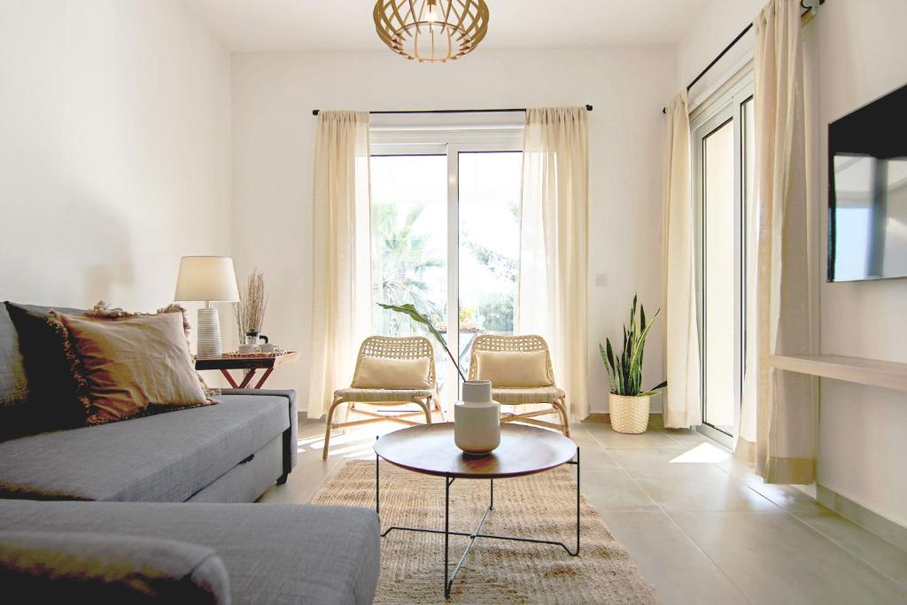 uma sala de estar com um sofá e uma mesa em Phaedrus Living Seaview Luxury Flat Limnaria 153 em Pafos