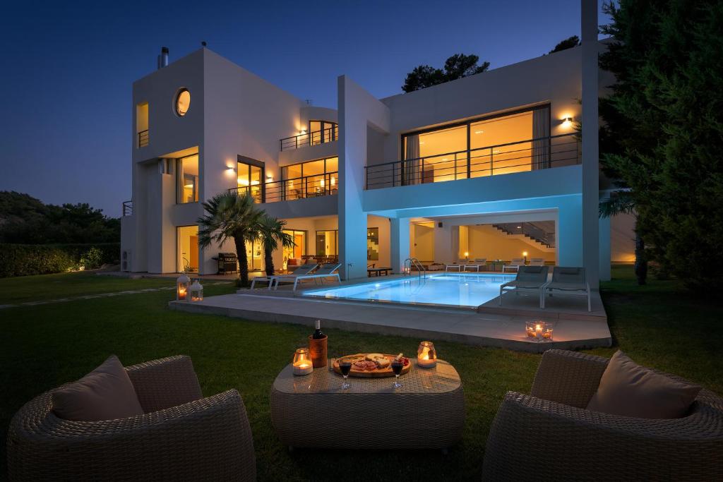 a villa with a swimming pool at night at Ixian Hilltop Villa in Ialysos