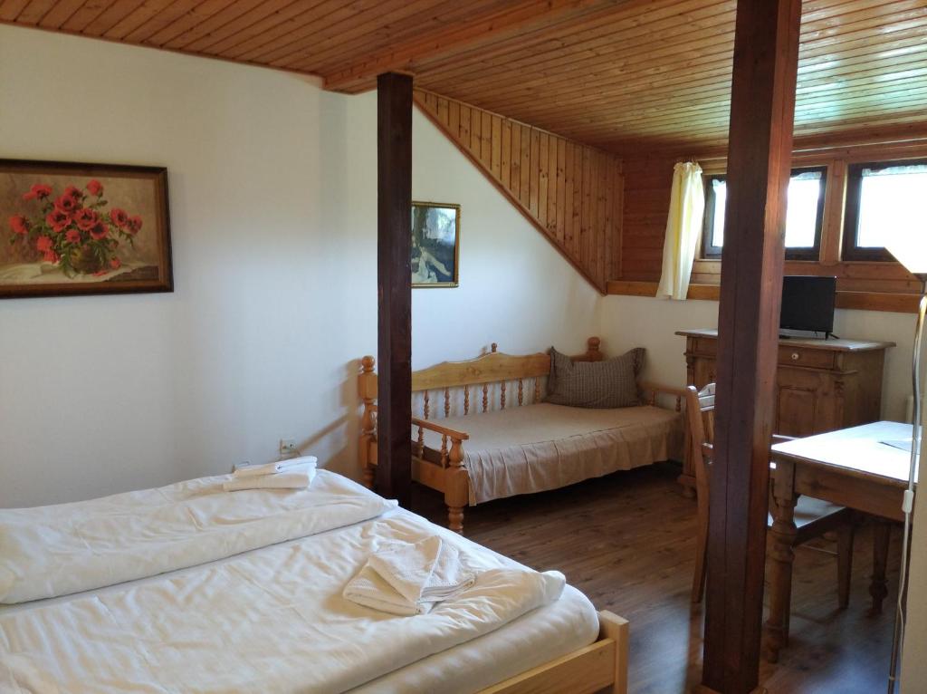 sypialnia z 2 łóżkami i biurkiem w pokoju w obiekcie Hotel v Nebi w mieście Josefuv dul