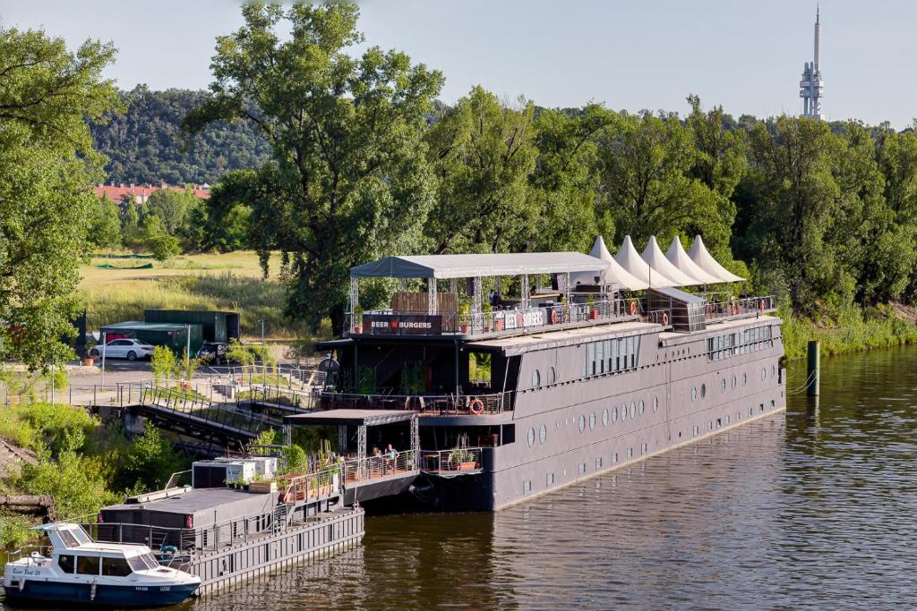 a large boat is docked on a river at Botel Marina in Prague