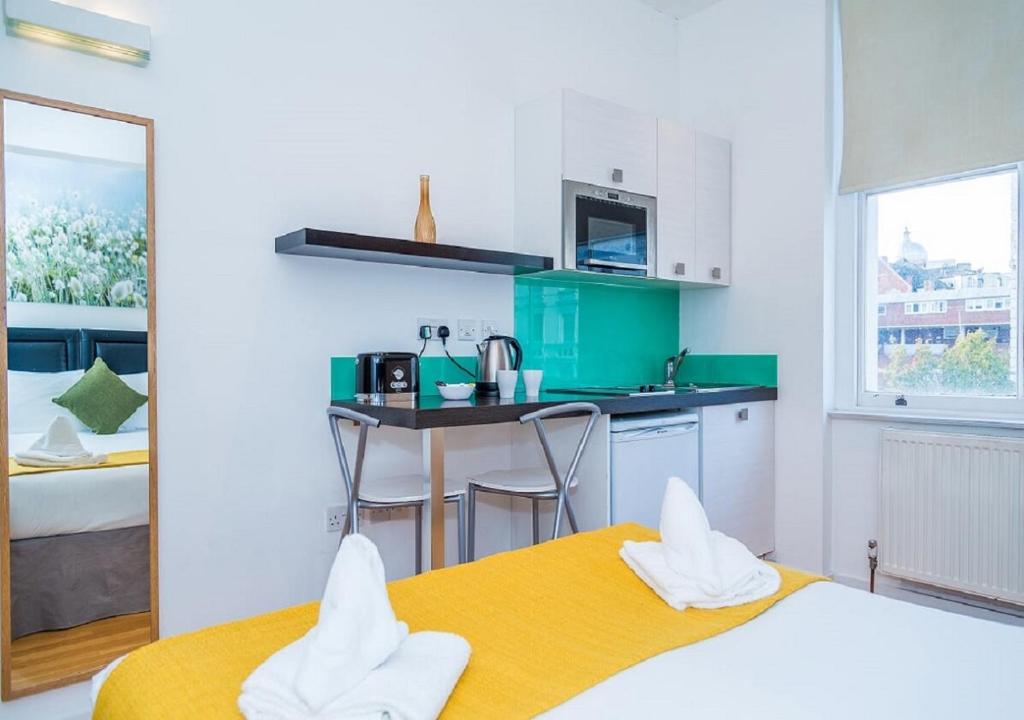 Pokój z 2 łóżkami i kuchnią z blatem w obiekcie Hyde Park Executive Apartments w Londynie