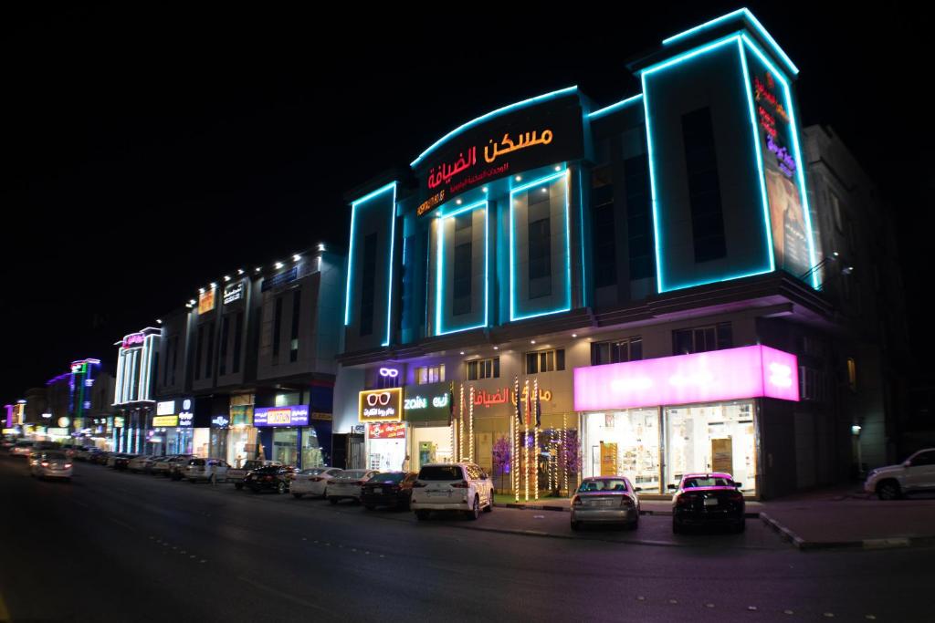 eine Straße mit Autos, die vor einem Gebäude geparkt sind in der Unterkunft Maskan Al Dyafah Hotel Apartments 2 in Dammam