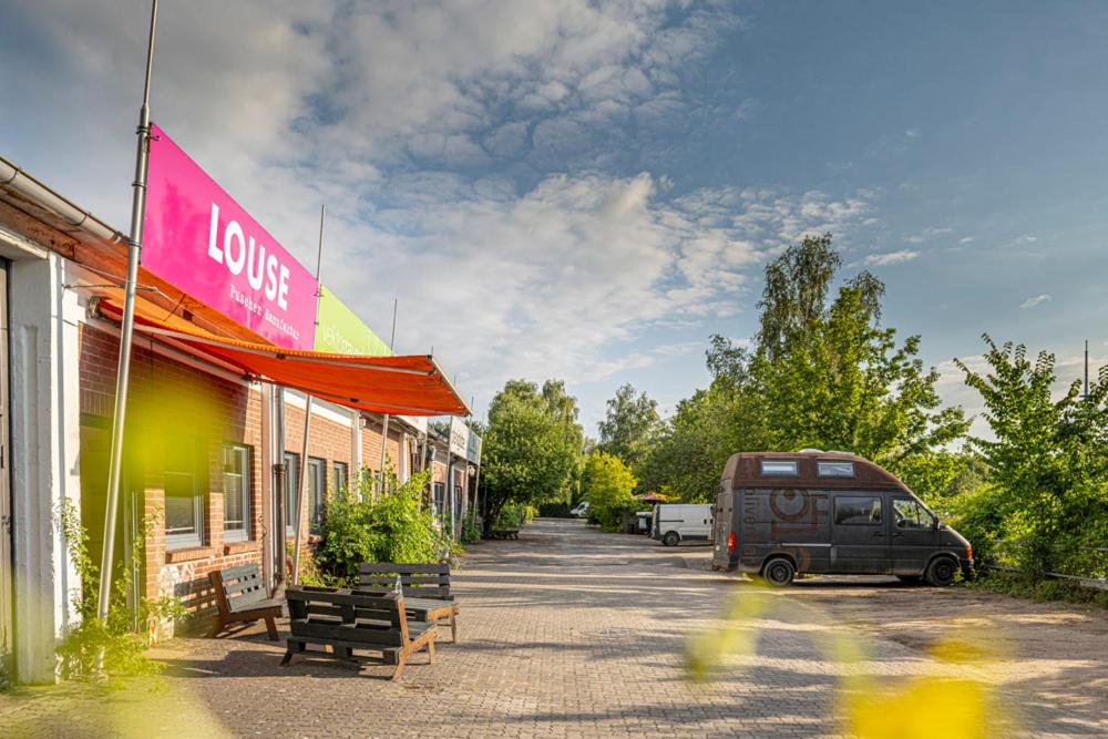 ein Van auf einer Straße neben einem Gebäude geparkt in der Unterkunft Louse Puschen Manufaktur in Kiel