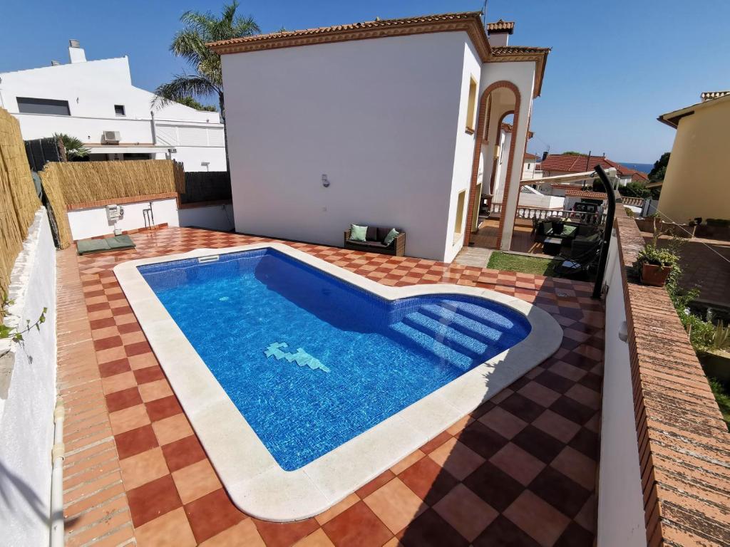 a swimming pool on a patio with a house at Villa Arcos in Segur de Calafell