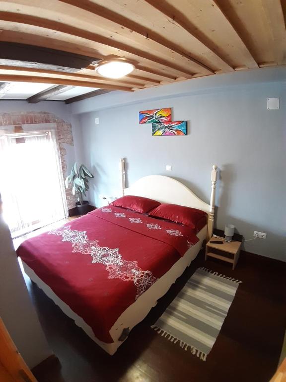 1 dormitorio con cama roja y ventana en Apartament Mario, en Sibiu