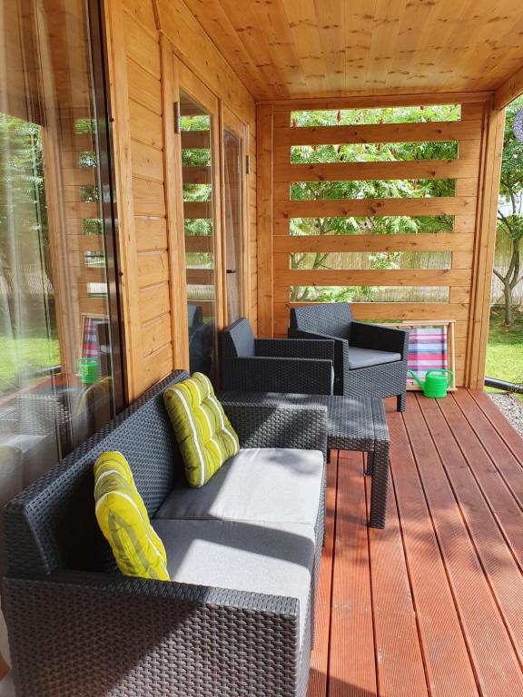 a screened in porch with a couch and chairs at Dom Pod Sosnami in Lidzbark