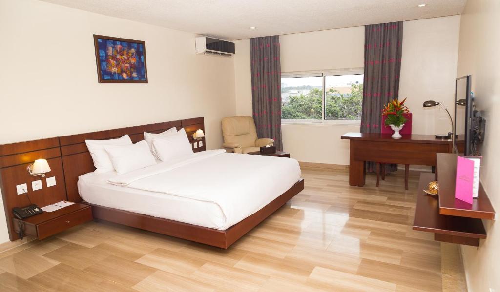 a hotel room with a bed and a desk and a desk at Hotel du Golfe in Lomé