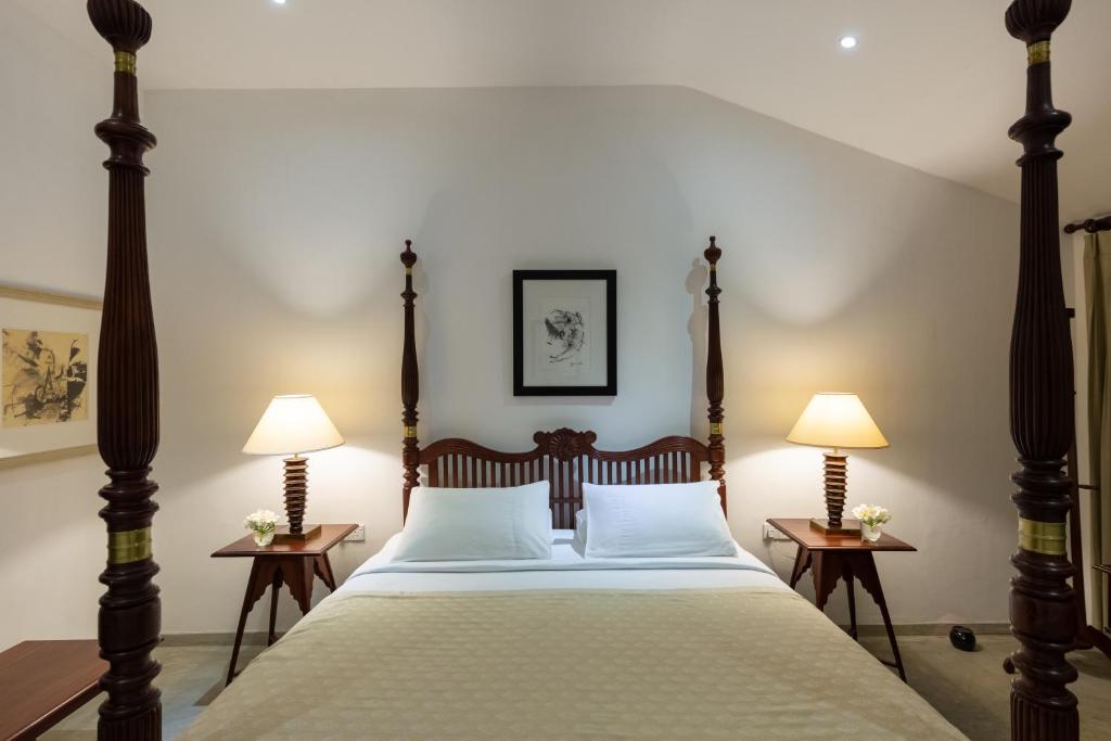 a bedroom with a large bed with two lamps at Nyne Hotels Rock Villa, Bentota in Bentota