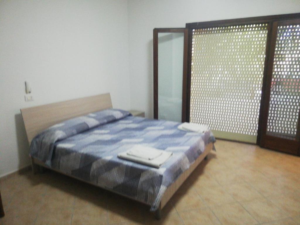1 dormitorio con cama y ventana grande en Callipigia, en Marsala