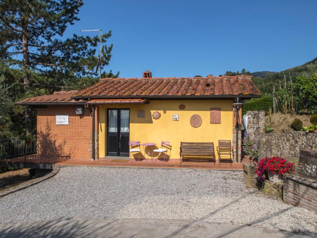 mały żółty dom z ławką i stołem w obiekcie Holiday Home Al Melo by Interhome w mieście San Gennaro