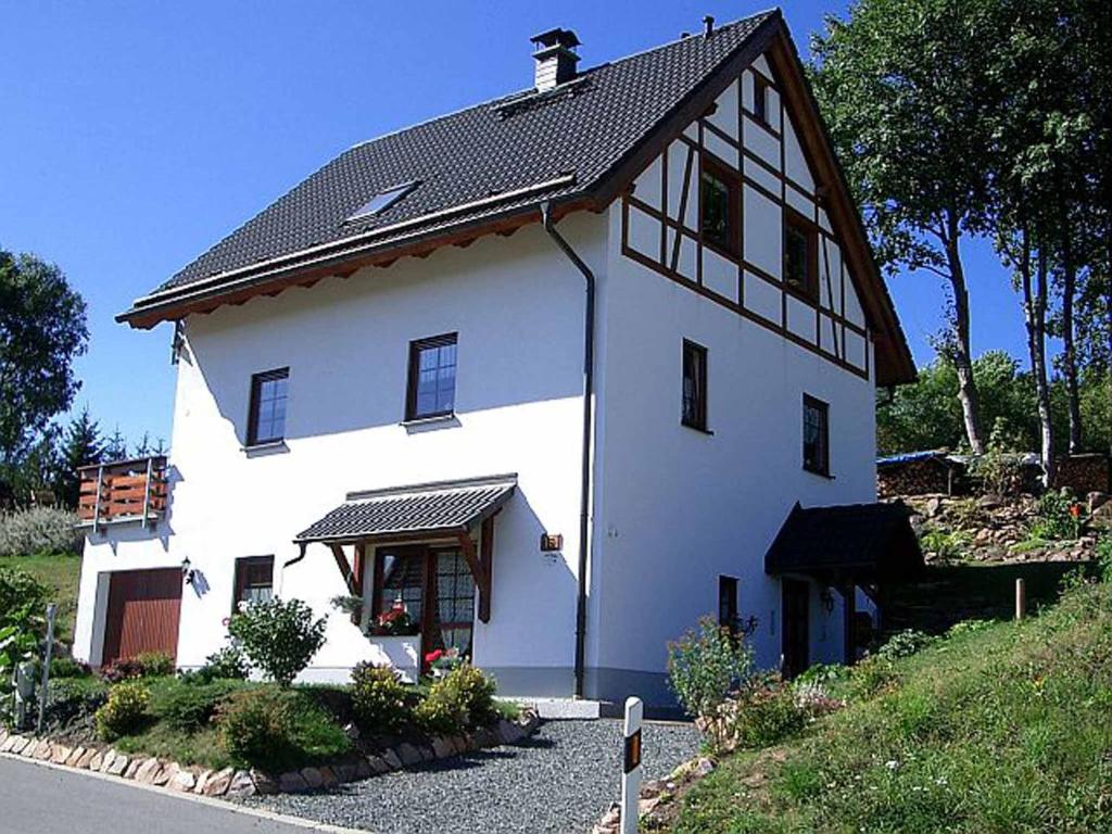 een groot wit huis met een zwart dak bij Ferienwohnung Lohse in Kurort Altenberg