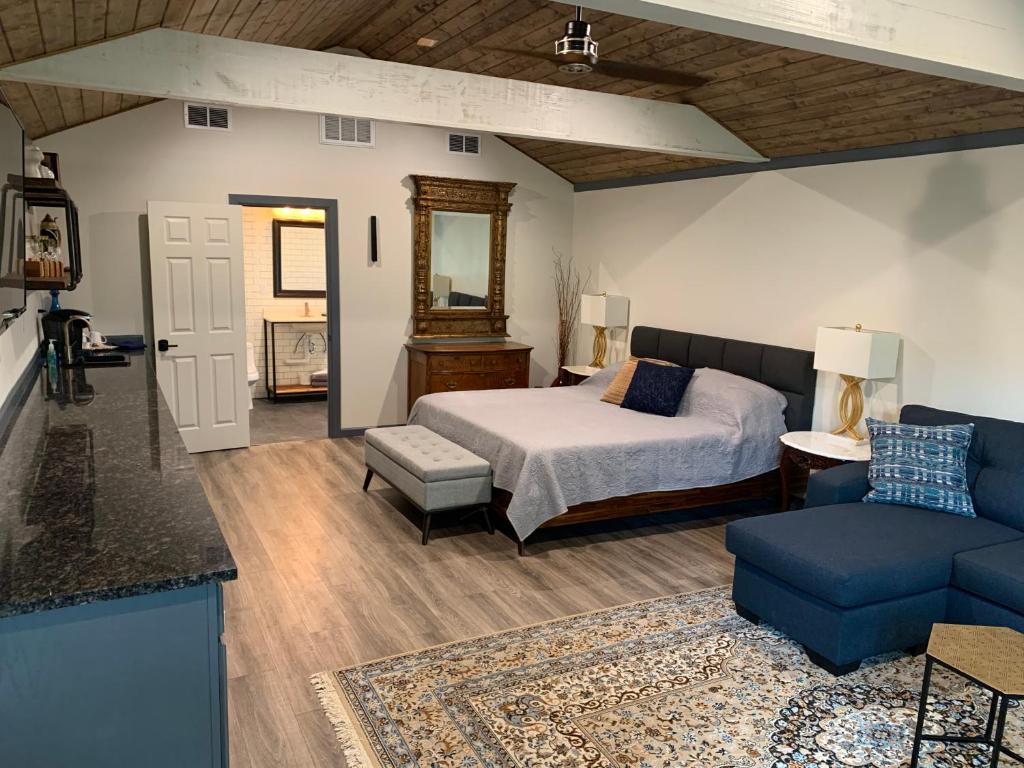 a bedroom with a bed and a blue couch at Salado Cottage Retreat near Downtown in Salado