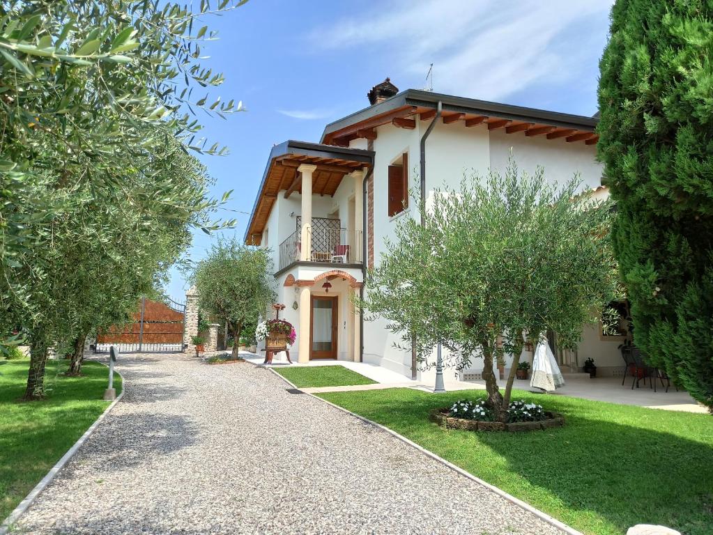 a villa with a garden and a walkway at Le Zampolle B & B in Colà di Lazise