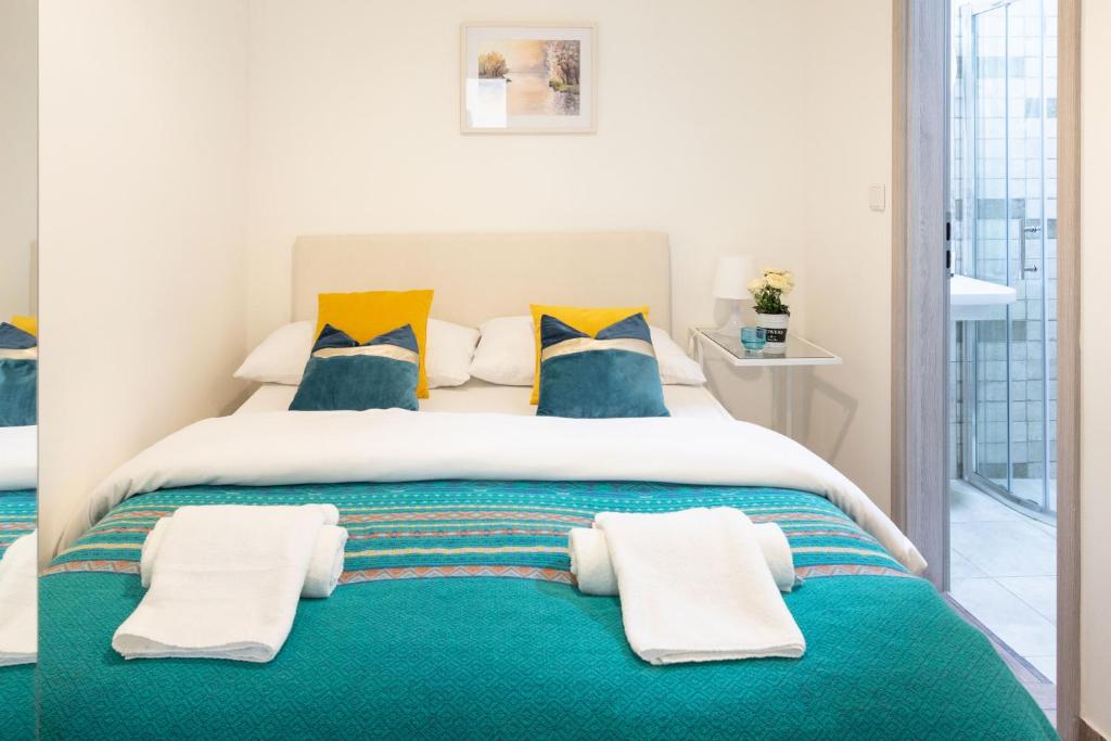 a bedroom with a large bed with blue and yellow pillows at Rooms 88 in Zagreb