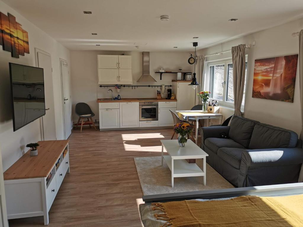 a living room with a couch and a kitchen at FeWo Himbeerweg in Tutzing