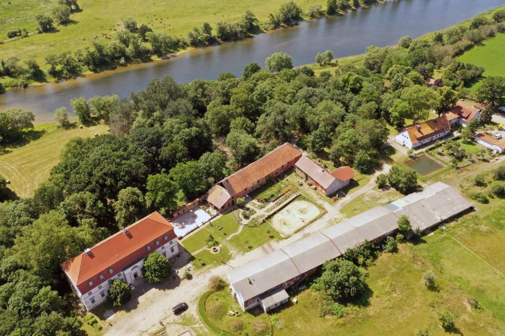 eine Luftansicht eines Gebäudes neben einem Fluss in der Unterkunft Gutshof Elbschloss Kehnert - Pension & Ferienwohnungen in Kehnert