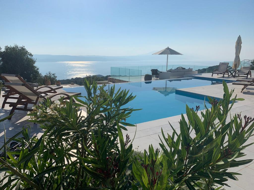 KechriaにあるVilla Salina Luxury Pool Villaの海の景色を望むスイミングプール(椅子付)