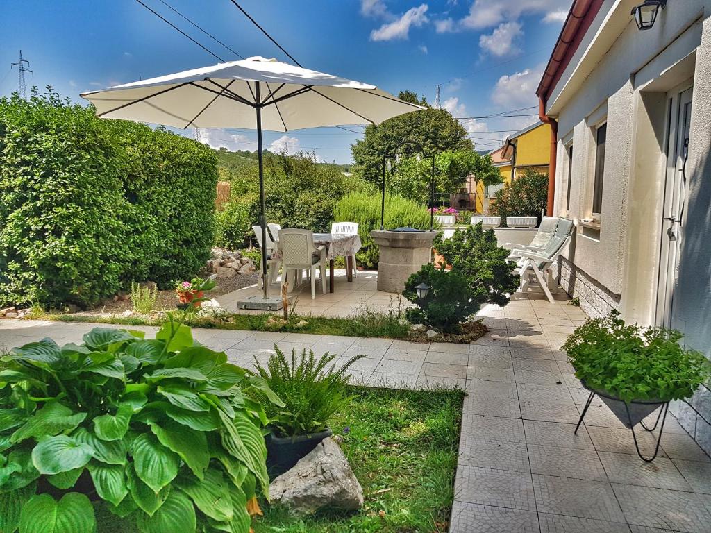 een patio met een parasol, stoelen en planten bij Rijeka holiday home in Krasica
