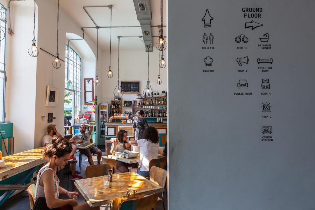 a group of people sitting at tables in a restaurant at Madama Hostel & Bistrot in Milan