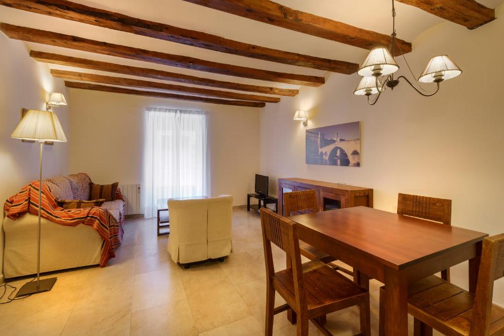 ein Wohnzimmer mit einem Esstisch und Stühlen in der Unterkunft Apartamentos Casa Les Valeres in Fuentespalda