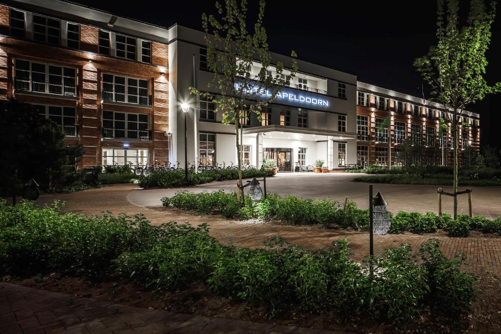 un bâtiment universitaire la nuit avec un panneau sur celui-ci dans l'établissement Van der Valk Hotel Apeldoorn, à Apeldoorn