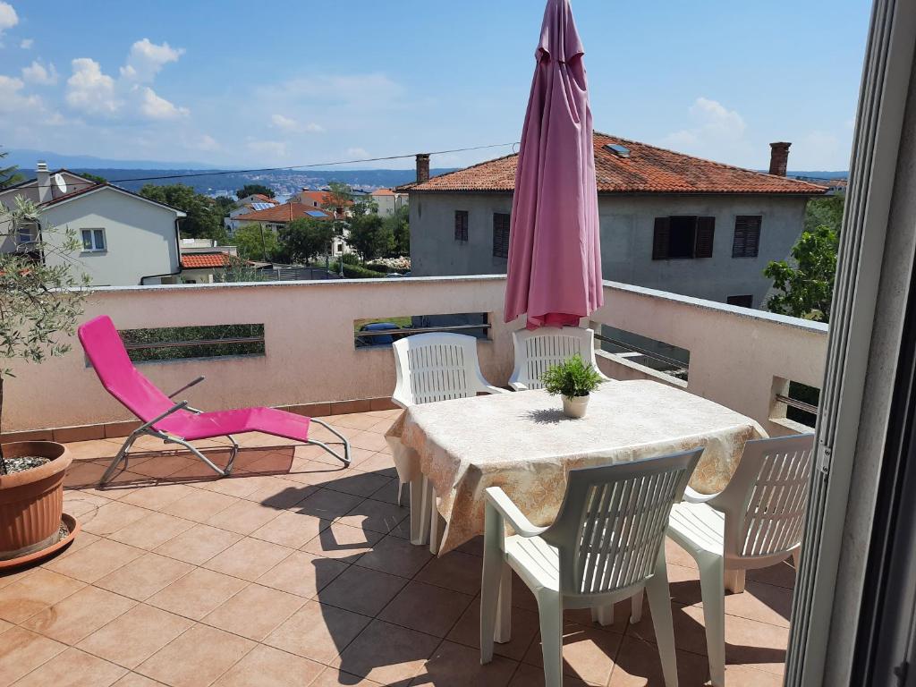 a patio with a table and chairs and an umbrella at Apartments Porat in Porat