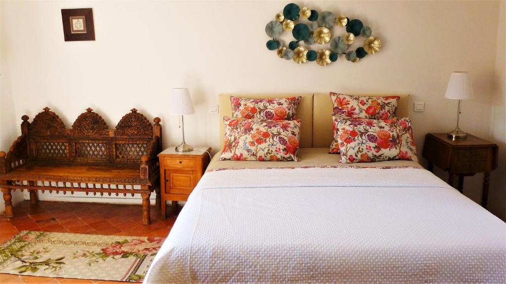 um quarto com uma cama branca com almofadas em La Cachette village em Roussillon