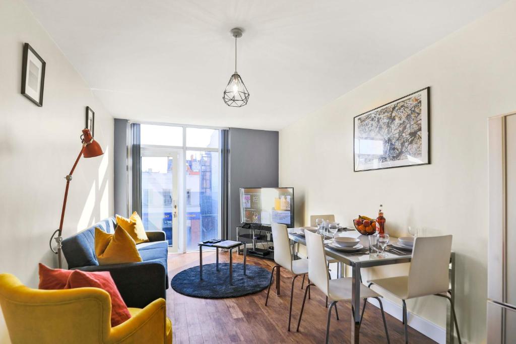 een eetkamer en een woonkamer met een tafel en stoelen bij UR STAY Apartments Leicester in Leicester