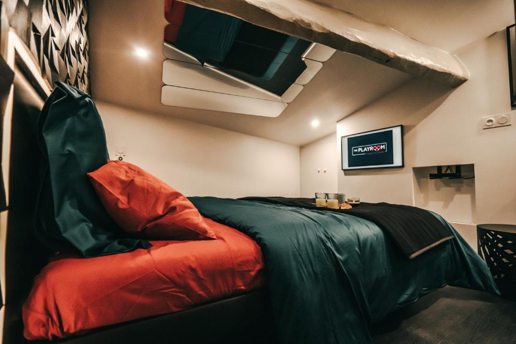 a room with a bed and a tv on the wall at LOVE ROOM Bordeaux Playroom avec salle de jeux pour adultes et lit à eau chauffant in Bordeaux