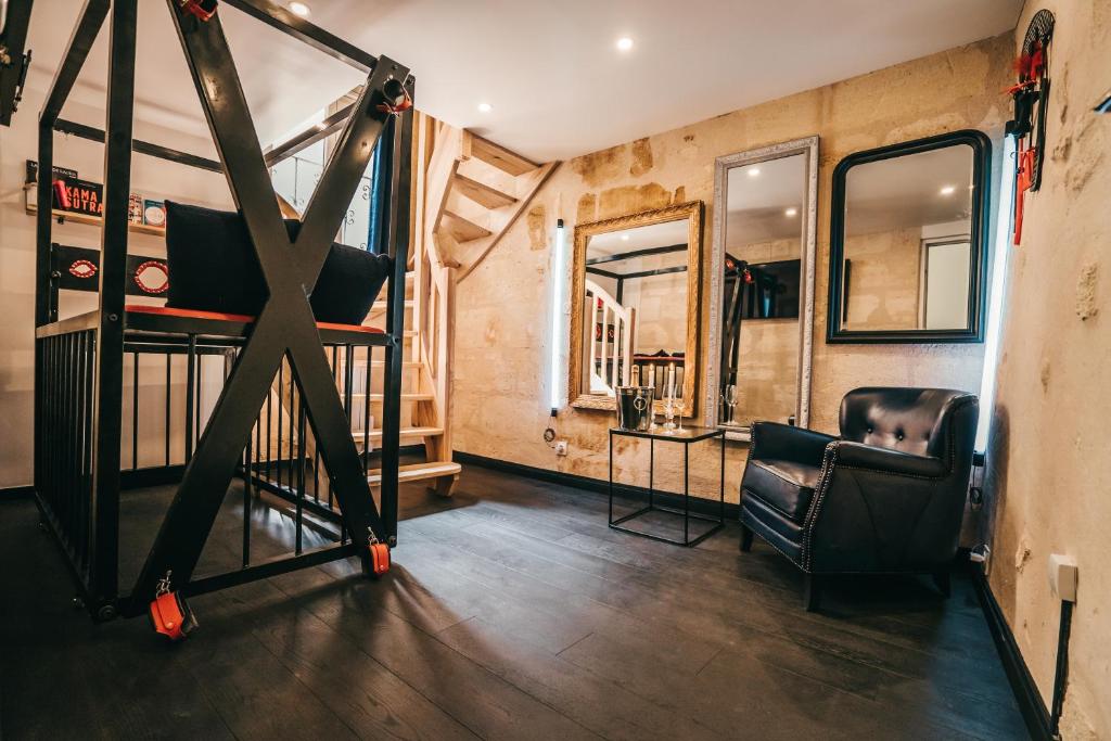 a room with a bunk bed and a chair at LOVE ROOM Bordeaux Playroom avec salle de jeux pour adultes et lit à eau chauffant in Bordeaux