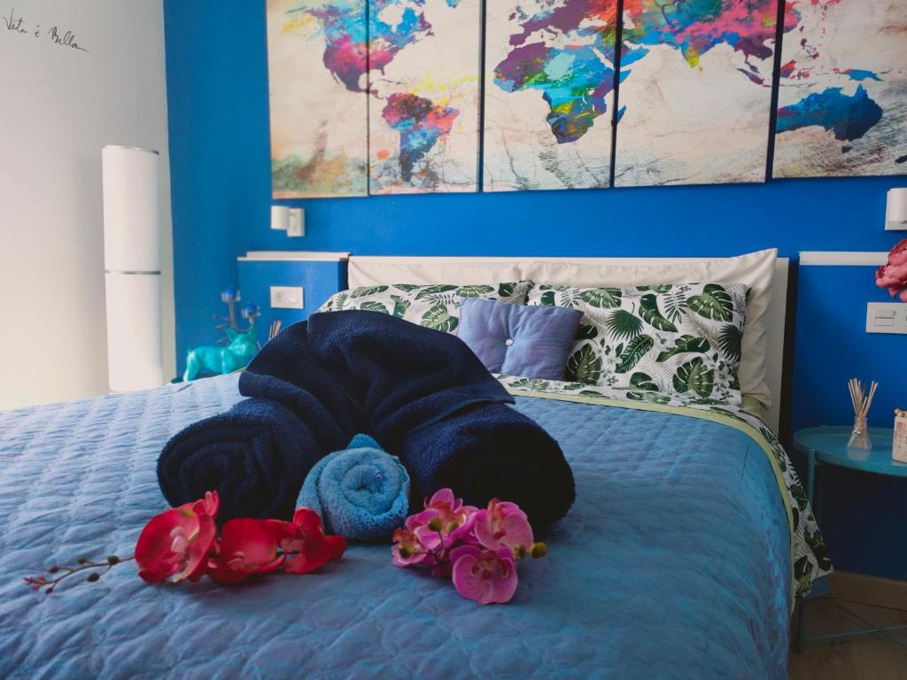 een bed met een blauwe deken en bloemen erop bij Lagunillas Travel Loft in Málaga