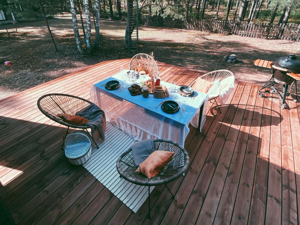 ein Tisch und Stühle auf einer Terrasse mit einem blauen Tisch und Stühlen in der Unterkunft Peledos troba in Žiūrai