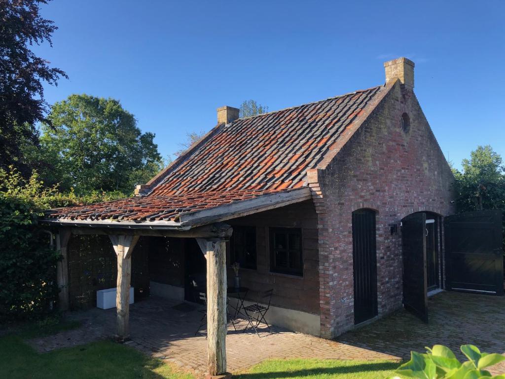 una casa de ladrillo con techo en un patio en Paradise Garage, en Hilvarenbeek