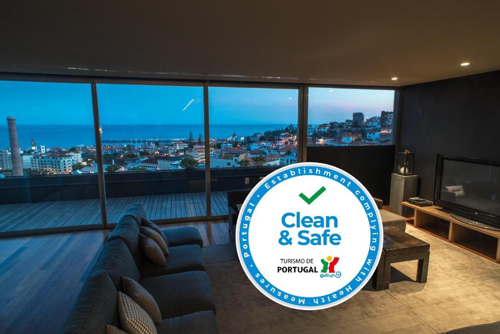 ein Schild, auf dem steht: sauber und sicher in einem Zimmer mit Sofa in der Unterkunft ARTS In Penthouse Apartments Til Sol in Funchal
